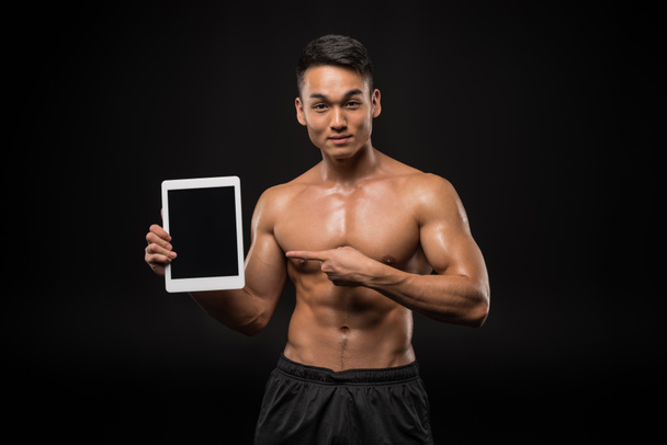 Homme musculaire avec tablette numérique
 - Photo, image
