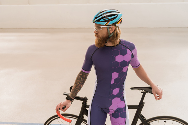 велосипедист в шлеме с велосипедом
 - Фото, изображение