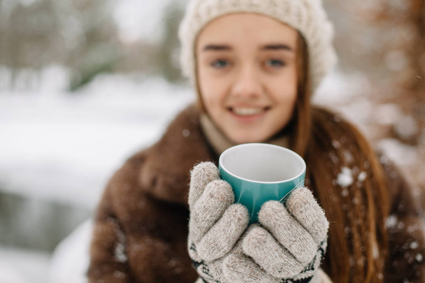 junge Frau mit warmem Becher Winterporträt. - Foto, Bild