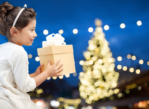 happy girl with gift box over christmas lights - Foto, imagen