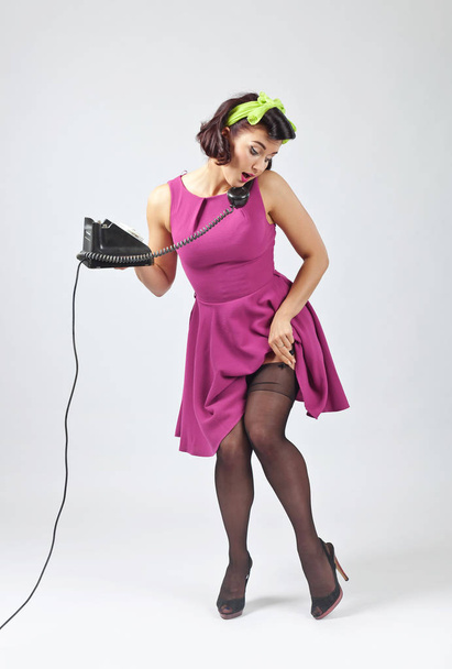 Beautiful woman in pin up style with vintage phone. - Foto, Bild