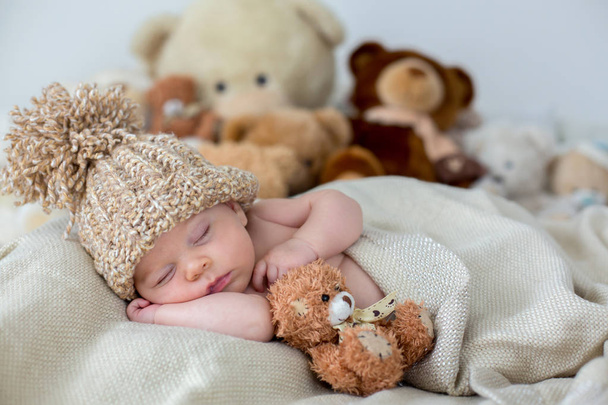 Little newborn baby boy, sleeping with teddy bear at home in bed - Fotoğraf, Görsel