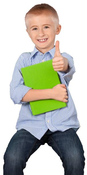 Αγόρι σχολείο με βιβλίο δείχνει τον αντίχειρα επάνω απομονωθεί σε λευκό φόντο - Φωτογραφία, εικόνα