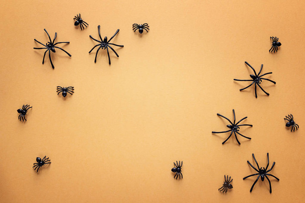 Halloween background with decorative spiders on orange backdrop. - Фото, изображение