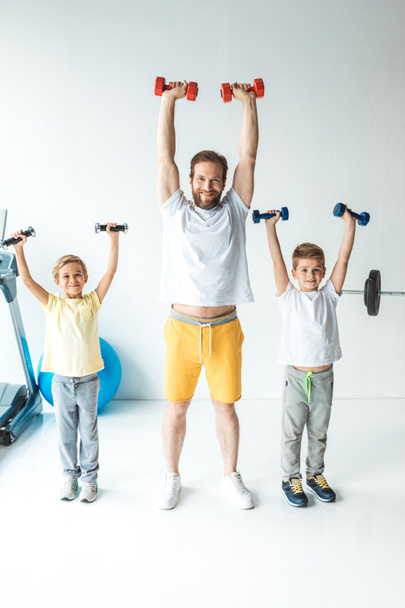 padre e hijos haciendo ejercicio con pesas
 - Foto, Imagen