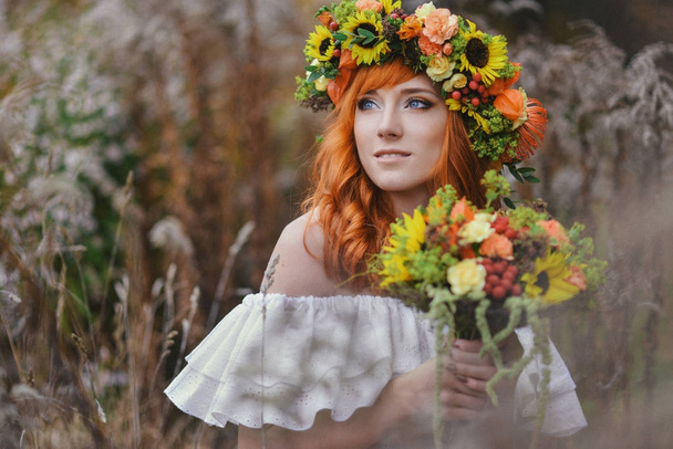 autumn portrait of romantic redhead woman with flowers in her hair in a wreath - Zdjęcie, obraz