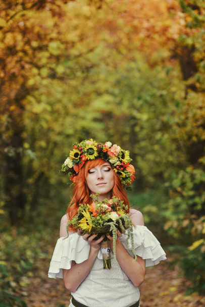 autumn portrait of romantic redhead woman with flowers in her hair in a wreath - Foto, imagen