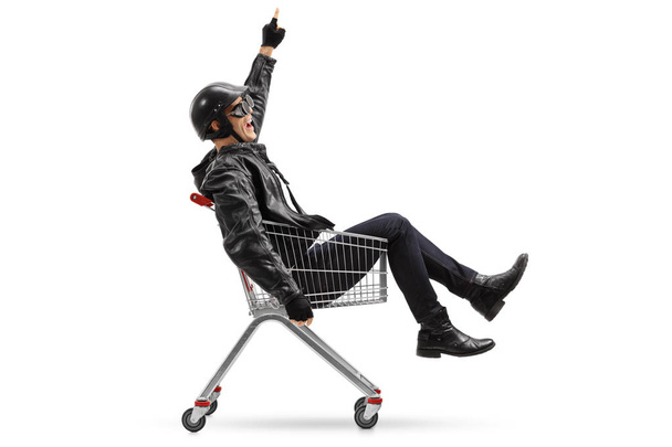 biker riding in a shopping cart and pointing up - Fotoğraf, Görsel