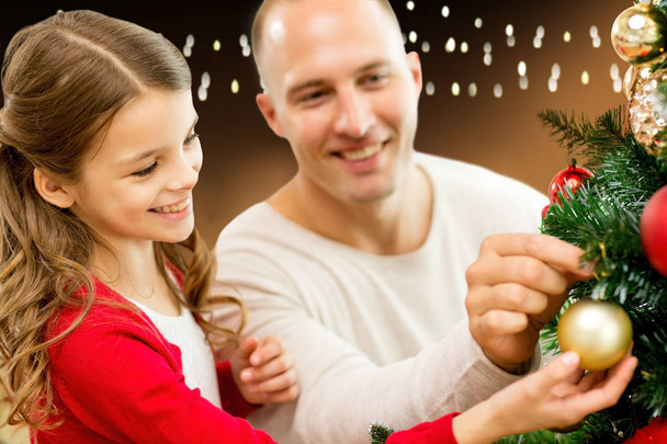 happy family decorating christmas tree at home - Фото, изображение