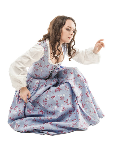 Νεαρή όμορφη γυναίκα στο μακρύ μεσαιωνικό φόρεμα κάθεται απομονωμένος  - Φωτογραφία, εικόνα