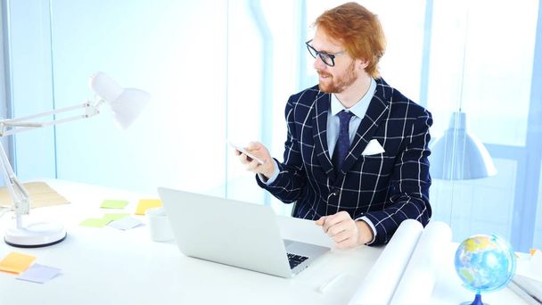 Redhead Man Using Smartphone for Online Browsing, Designer - Valokuva, kuva