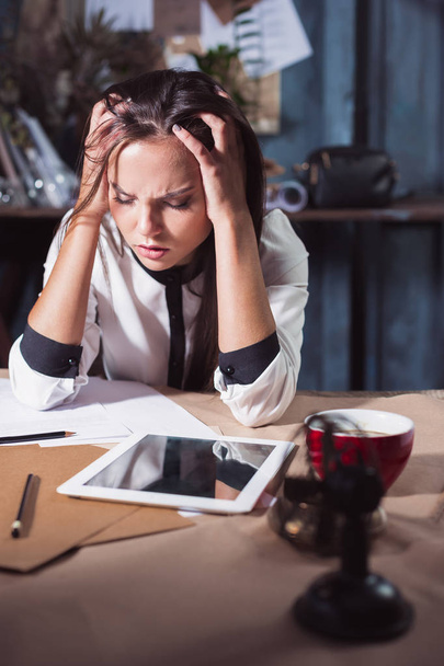 Young frustrated woman working at office desk in front of laptop - Photo, Image