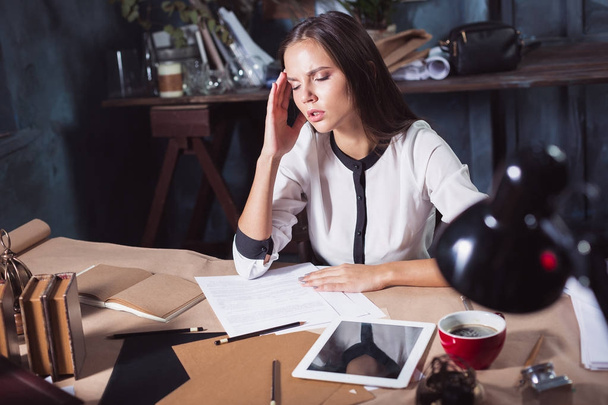 Young frustrated woman working at office desk in front of laptop - 写真・画像