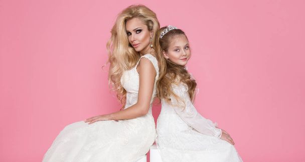 schöne blonde weibliche Modell, Mutter mit blonder Tochter in Kleidern. Sie haben wunderschöne Brautkleider - Foto, Bild