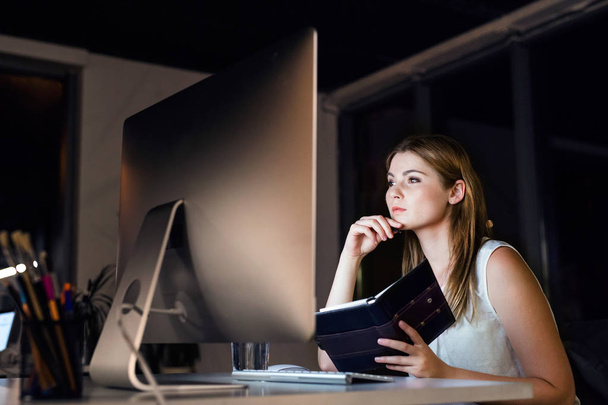Businesswoman in her office at night working late. - Foto, imagen