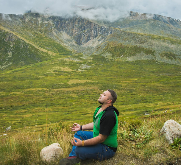 portrait of adult man resting on the nature. man in lotus pose,  yoga exersice. closed eyes - Fotoğraf, Görsel