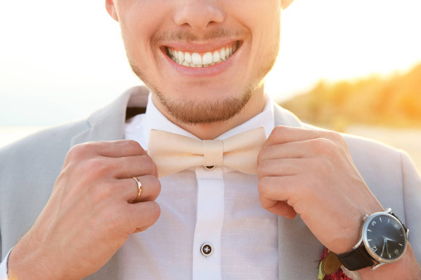 Handsome groom in wedding suit on beach, closeup - Foto, Bild