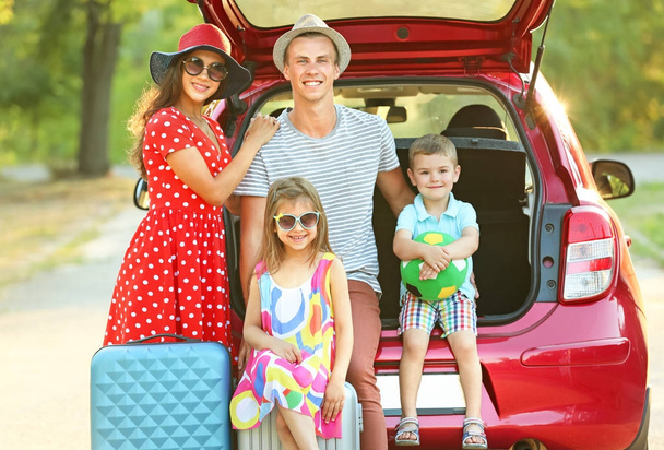 Happy family next to car in countryside - Фото, изображение