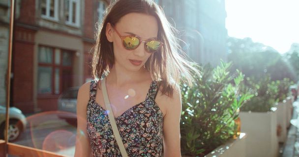 Portrait of beautiful girl wearing sunglasses standing in a city street.  - Foto, Imagen
