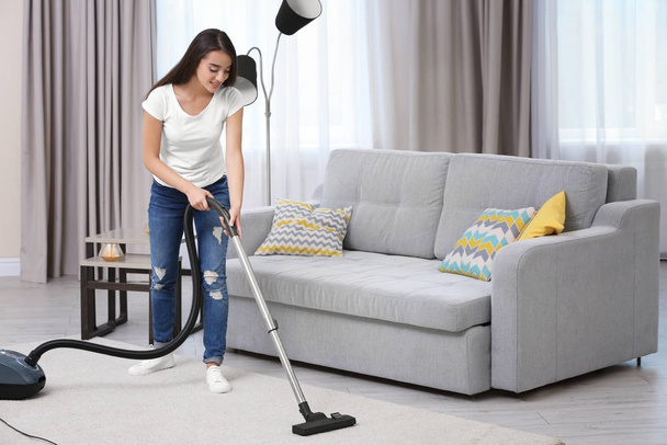 Woman cleaning carpet with vacuum - 写真・画像
