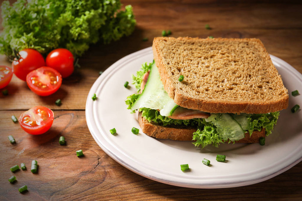 Plate of tasty sandwich with fresh cucumber - Photo, image