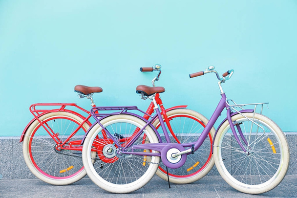 Stylish new bicycles near color wall outdoors - Photo, Image