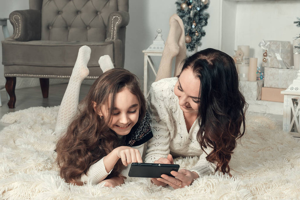Two cute girls, mother and daughter lying on a floor in Christma - Photo, Image