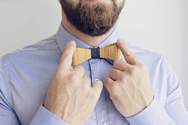 Parrakas mies säätää solmiota
 - Valokuva, kuva