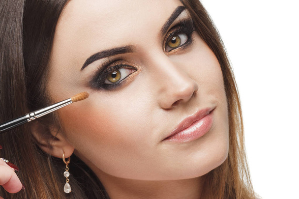 Beautiful woman with a brush for makeup in the hand - Foto, Imagen