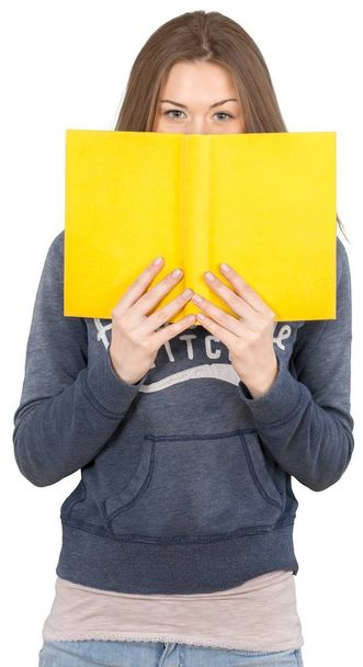portrait of pretty young woman with yellow book on background - Фото, зображення