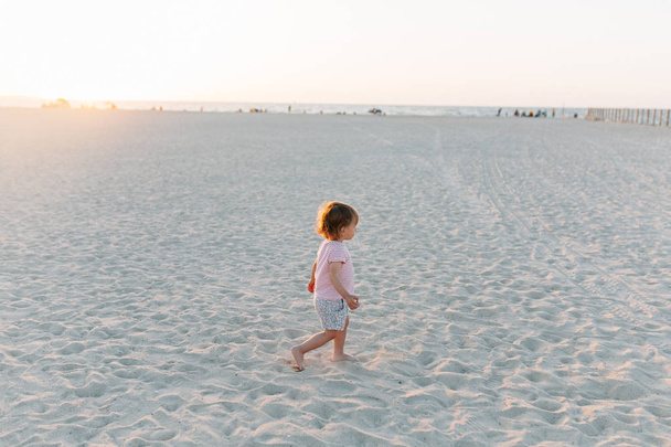 kisgyermek lány homokos strandon - Fotó, kép