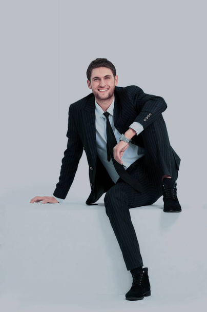 handsome young business man sitting on a white modern chair - Foto, afbeelding