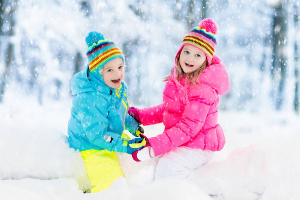 Des enfants qui jouent dans la neige. Les enfants jouent dehors dans les chutes de neige d'hiver
. - Photo, image