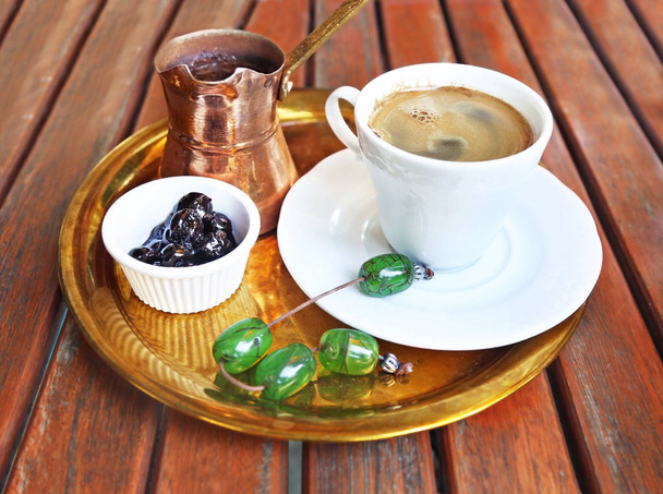 traditioneller griechischer Kaffee mit Kaffeekanne, Süßkirsche und Rosenkranz  - Foto, Bild
