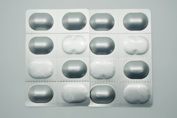 Blistrové balení pilulek na bílém pozadí, chrání před světla balení - Fotografie, Obrázek