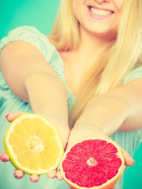 Woman holds grapefruit citrus fruit in hands - Foto, imagen