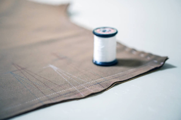 белая нитка для шитья и ткань для изготовления ткани
 - Фото, изображение