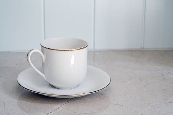 a white ceramic cup with golden stripe  - Zdjęcie, obraz