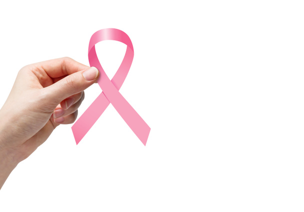 Woman hand holding pink ribbon for breast cancer awareness on white background - Photo, Image