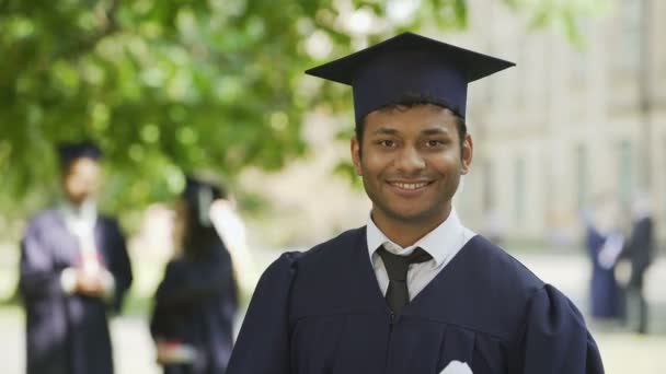 Sourire étudiant hispanique diplômé se réjouissant diplôme, succès, posant pour la caméra
 - Séquence, vidéo