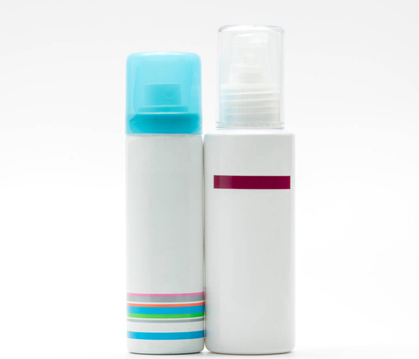 Σπρέι μπουκάλι με μπλε πώμα και αντλία μπουκάλι περιποίηση δέρματος σε λευκό φόντο, λευκά label - Φωτογραφία, εικόνα