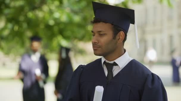 Okouzlující hispánské absolvent usmívá a ukazující diplom pro fotoaparát, úspěch - Záběry, video
