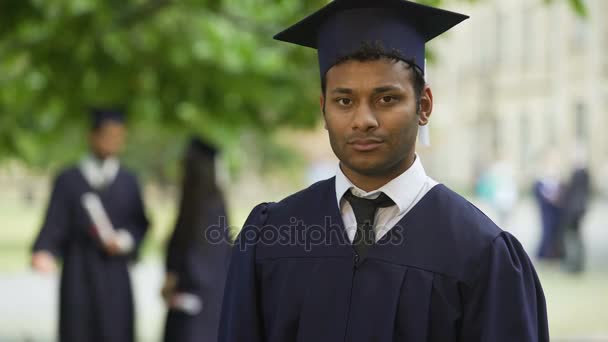 Ernsthafter Absolvent kreuzt die Arme mit dem Diplom in der Hand, Abschluss des Studiums Stolz - Filmmaterial, Video