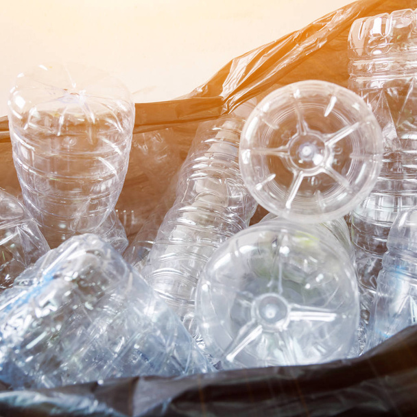 Műanyag palackok fekete szemeteszsákban, az újrahasznosításra várva. - Fotó, kép
