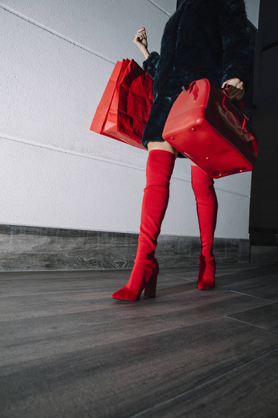 piernas hermosa mujer de compras en la calle, botas rojas y bolsa
 - Foto, Imagen