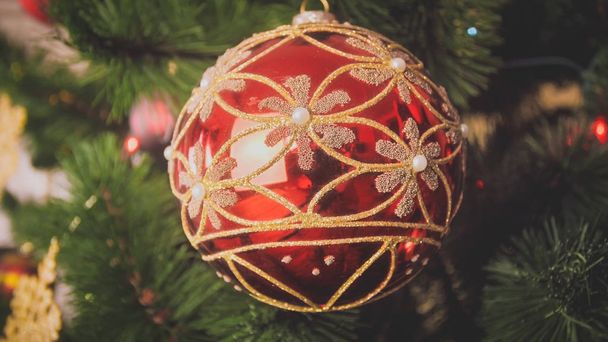 Image rapprochée du rouge avec une boule d'or accrochée au sapin de Noël
 - Photo, image
