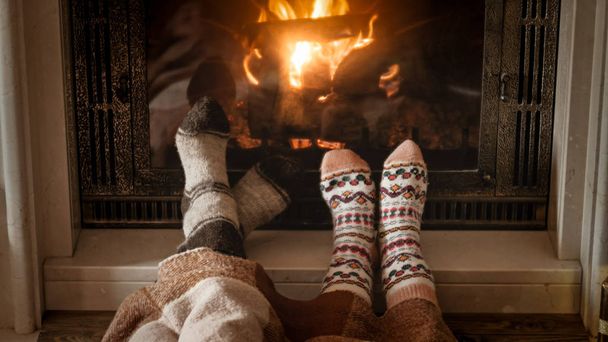 Hombre y mujer de calentamiento y relajarse junto a la chimenea en el día frío
 - Foto, Imagen