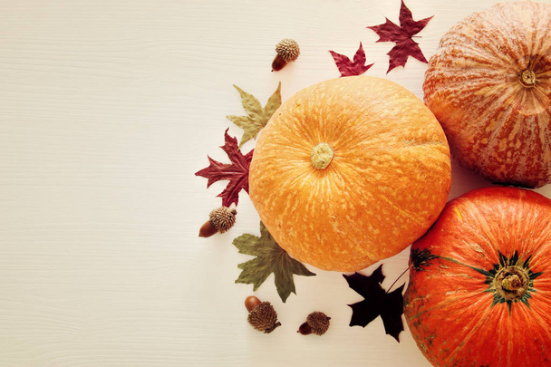 Pumpkins and autumn leaves on wooden background. thanksgiving and halloween concept. Top view. - 写真・画像