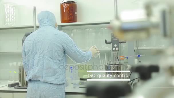 Rear view of a male scientist in a protective suit working with specimen bottles in laboratory. Rear view of a scientist in a chemical laboratory - Footage, Video