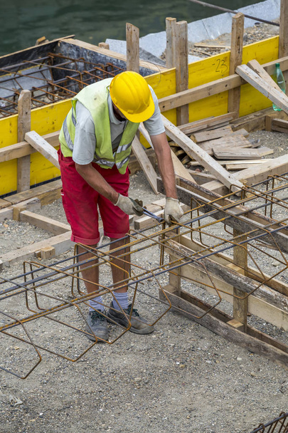 Εργαζόμενος στο χώρο της οικοδομής, καθιστώντας ενίσχυση μέταλλο - Φωτογραφία, εικόνα